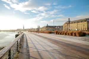 Quais de Bordeaux en hiver avec une légère couverture de neige et une vue sur la Place de la Bourse.